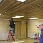 Rick mulls over tool selection while Chris installs moulding.
