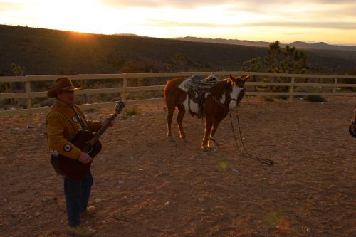 CRW_3718.JPG - Mike, our entertainer, doing a few western songs at sunset.  I like the expression of the horse.
