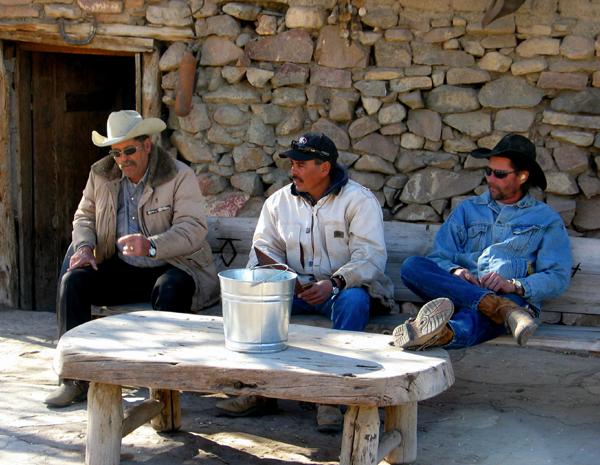 master_1929.jpg - Three of our wranglers relax in front of the original settler's cabin.